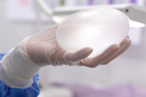 Person holding textured breast implant in OR