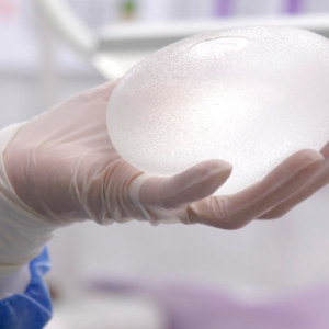 Person holding textured breast implant in OR