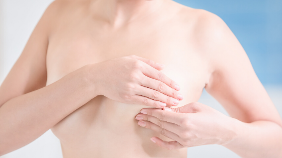 Image of woman feeling for a breast lump wondering what to do when she finds a breast lump