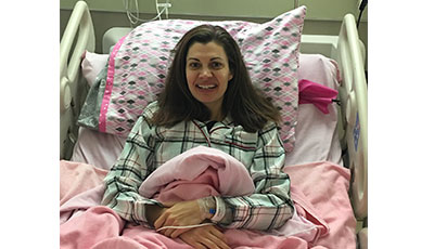 Anne Peled, MD in a hospital bed smiling after surgery